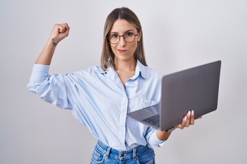 Young woman working using computer laptop strong person showing arm muscle, confident and proud of...