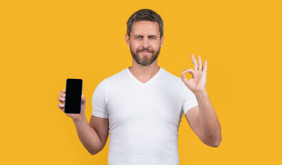 man showing phone screen with copy space show ok. man showing phone screen