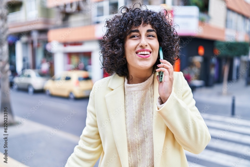 Canvas Prints Young middle east woman excutive smiling confident talking on the smartphone at street