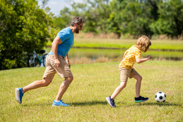 Obraz na płótnie Canvas adventures between father and son. Active father son playing football in summer. Father and child son teaming up outdoor. Father dad and son enjoying outdoor activities together. having fun together