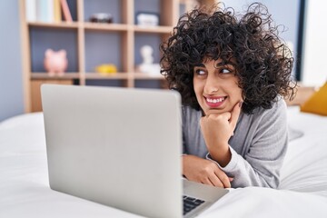 Young middle east woman using laptop lying on bed at bedroom