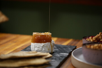 Uma combinação irresistível: queijo brie derretido, acompanhado de um delicioso favo de mel e crocantes. Uma explosão de sabores e texturas.