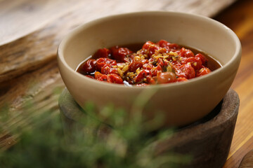 tomatinhos confit com alho em laminas dourados, servido como aperitivo em um evento delicioso