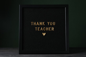 The inscription on the dark board: "Thank you, teacher!"