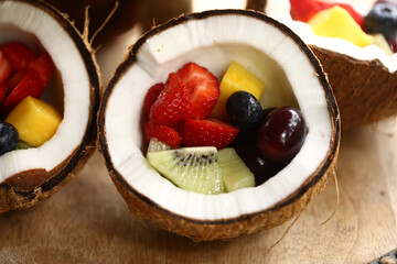 Uma explosão de cores e sabores: uma salada de frutas refrescante e saudável servida dentro da metade de um coco seco. Uma opção deliciosa para começar o dia com energia e nutrição.
