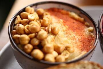 Três deliciosos tipos de homus de grão de bico, servidos com fatias de pão integral. Uma combinação perfeita de sabores e texturas em um evento gastronômico saudável e saboroso.