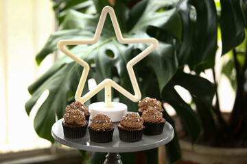 Cupcakes de chocolate decorados com estrelas prateadas, uma doce e encantadora adição à mesa de doces da festa de aniversário infantil.