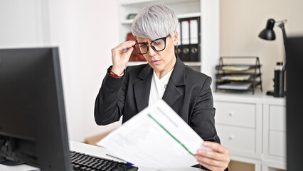 Young woman business worker using computer reading document at office