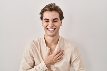 Young man standing over isolated background smiling and laughing hard out loud because funny crazy...