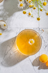 Chamomile tea on the light background close up. Top view - 622027778
