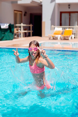 Naklejka premium Teenage girl jumping in pool