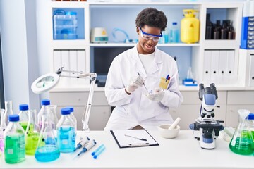 African american woman wearing scientist uniform working at laboratory