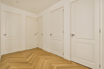 an empty room with wooden floors and white doors on either side of the room, there is no one door