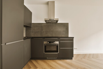 a modern kitchen with wood flooring and black appliances on the stove hood in the oven is built into the wall