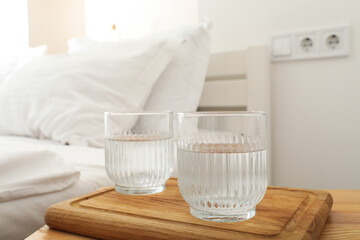 Glasses of water on a wooden board