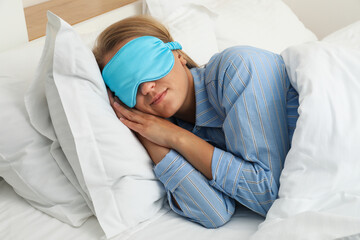 The girl is sleeping in bed, wearing a sleep mask