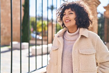 Young beautiful hispanic woman smiling confident looking to the side at street