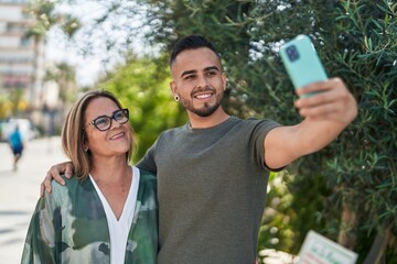 Man and woman mother and daugther make selfie by smartphone at park