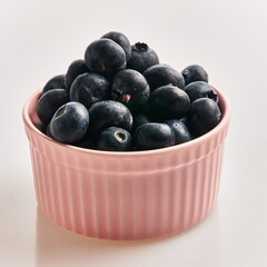  Delicious group of blueberries on ceramic bowl over isolated white background
