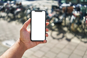 Man holding smartphone showing white blank screen at bike parking