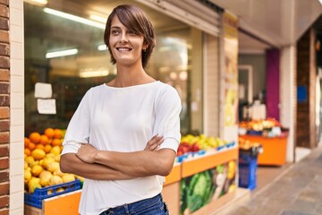 Young beautiful hispanic woman standing with arms crossed gesture at street