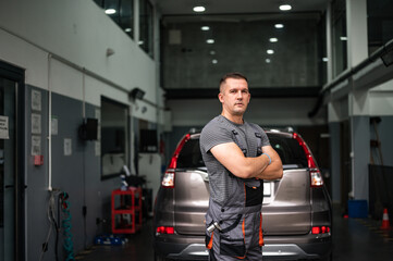 portrait of a mechanic in front of his workshop