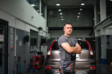 portrait of a mechanic in front of his workshop