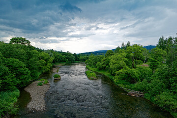 Krajobraz lata, zieleń i rzeka, pochmurne niebo. Bieszczady. © Adam Sadlak