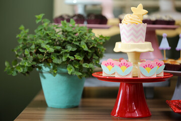 Um adorável cupcake decorado com uma estrela de açúcar, adicionando um toque mágico à mesa de doces da festa.