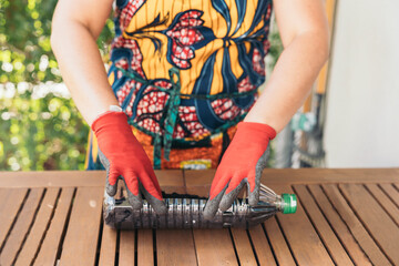 Woman reusing a plastic bottle to grow a plant,  recycling and sustainability concept
