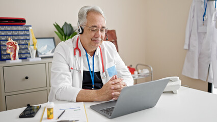 Middle age man with grey hair doctor doing online appointment at clinic