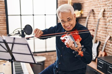 Senior man musician playing violin at music studio © Krakenimages.com
