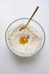 White flour with oil in glass bowl, ready to cook dough. Cooking homemade meal.