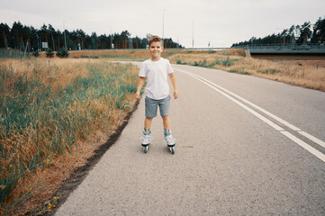 Smiling boy 7 years old rides on roller skates