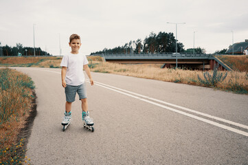 Smiling boy 7 years old rides on roller skates