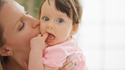 Mother and daughter hugging each other kissing at bedroom