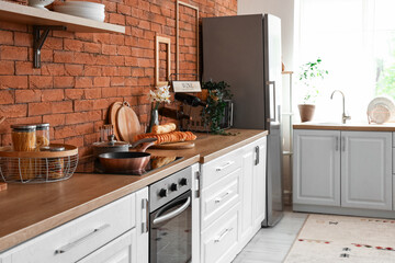 Interior of kitchen with stylish fridge, counters and utensils