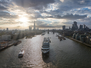 Large cruise ship going through London under the Tower Bridge. Visiting center of London. Tower bridge lifting up to let the ship enter London city center.