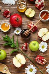 Composition with fresh fruits, flowers and honey on wooden background. Rosh hashanah (Jewish New Year) celebration