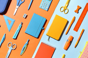 Set of notebooks and different school stationery on color background