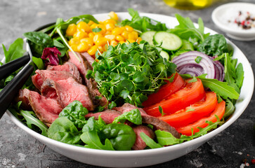 Beef steak and Fresh Vegetables Buddha Bowl, Healthy Balanced Meal on Dark Background