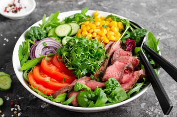 Beef steak and Fresh Vegetables Buddha Bowl, Healthy Balanced Meal on Dark Background