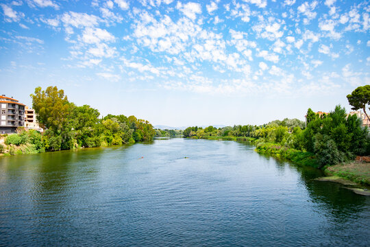 View of the Ebro River at the exit of the city of Tortosa on a bright summer day