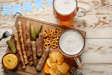 Mugs of cold beer and different snacks on light wooden background. Oktoberfest celebration