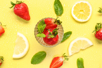 Glass of fresh lemonade with strawberry and lemon on yellow background