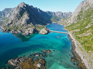 Fototapeta na wymiar une route en scandinavie entre grandes montagnes et eaux bleues transparentes