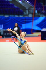 Beautiful girl gymnast performs with the hoop stretch