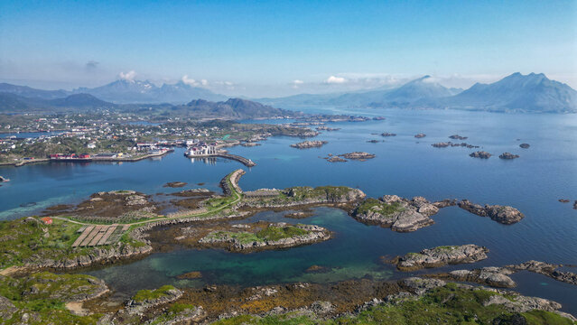 vue a&eacute;rienne sur un archipel d'&icirc;les avec de hautes montagnes en fond