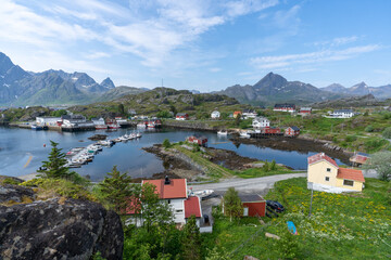 des maisons autour d'un petit port de plaisance avec les montagnes norvégienne en fond