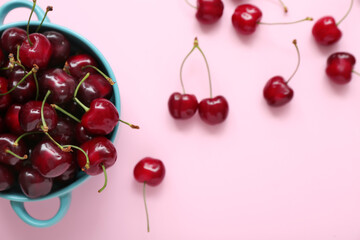 Fototapeta na wymiar Bowl with sweet cherries on pink background